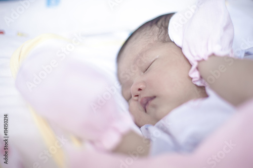 Newborn girl sleeping in her bed