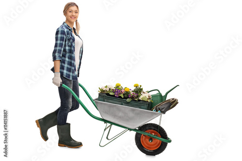 Photo Woman pushing a wheelbarrow with flowers