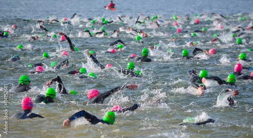 Fotografie Competitors swimming out into open water at the beginning of Triathlon