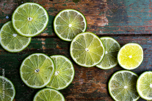Slices of lime on old wooden surface photo