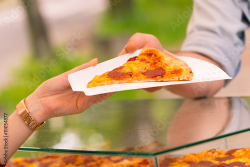 Man selling pizza by slice photo