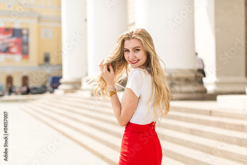 Young beautiful woman with long hair walking in city