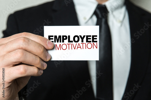 Business man holding a card with the text: Employee Motivation