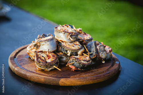 cooking rolls of mackerel on the grill, eating