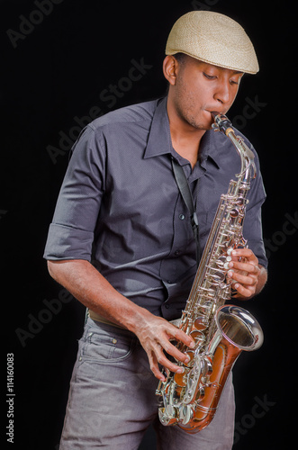 Black man playing the saxophone  feeling the music with white hat