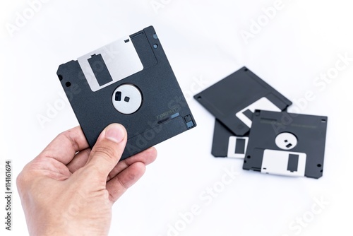 The old technology of storage - Hand holding Black Floppy Disk. isolated on white background for your text and design