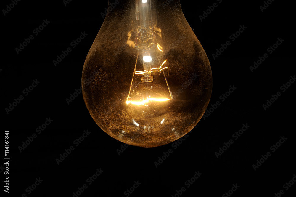 old light bulb glowing in dark