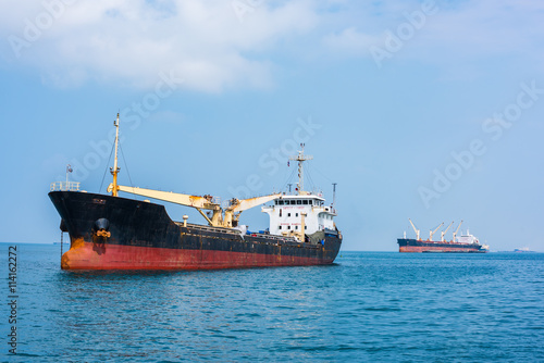 Cargo ships drop anchor at the harbor.