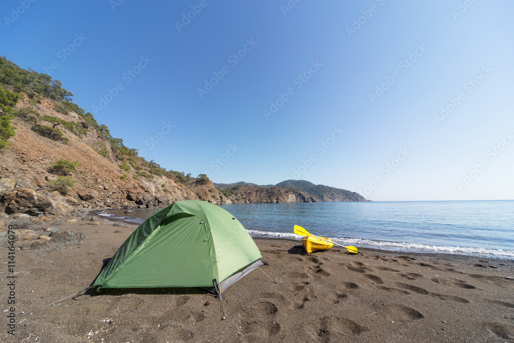 Camping with kayaks on the beach in summer.