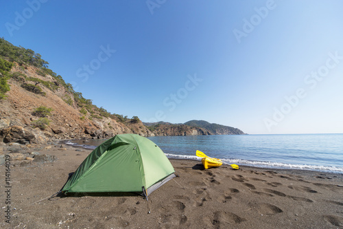 Camping with kayaks on the beach in summer.