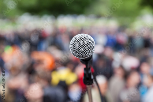 Microphone in focus against blurred crowd. Protest. © wellphoto