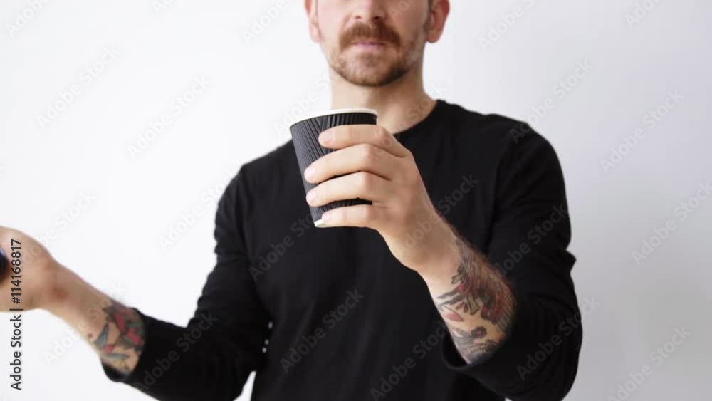 Bearded adult man unfocused opens and closes black cap of paper take away cup Bearded adult man unfocused opens and closes black cap of paper take away cup