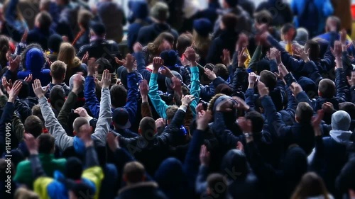 Many fans applauding and supporting soccer team at stadium, sporting event