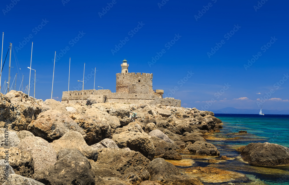 Rhodes harbor with the old fort in the background and stones in the foreground