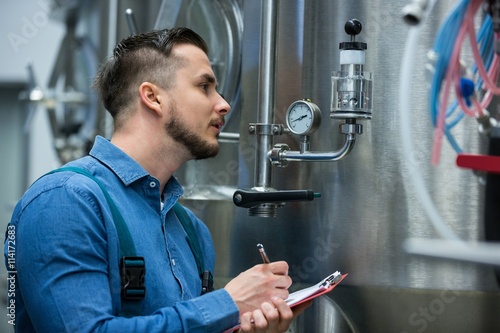 maintenance worker writing on clipboard photo