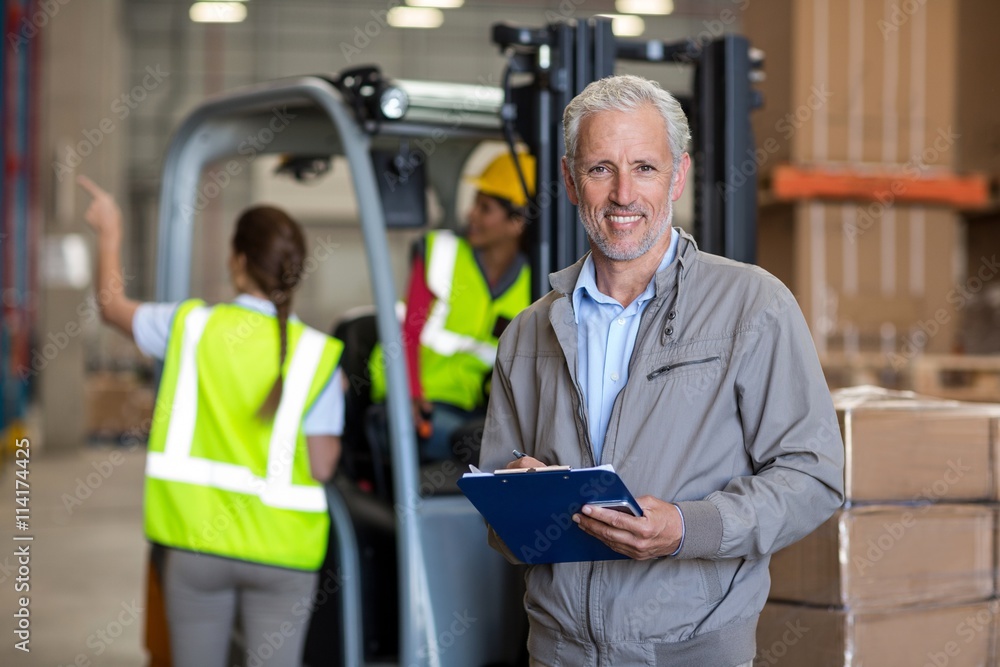 Portrait of worker holding a clipboard and looking the camera