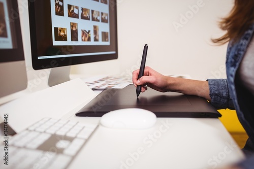 Midsection of photo editor using graphics tablet photo