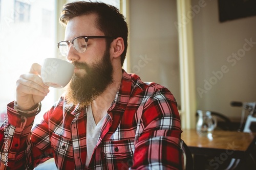 Customer sipping coffee from cup at cafe photo