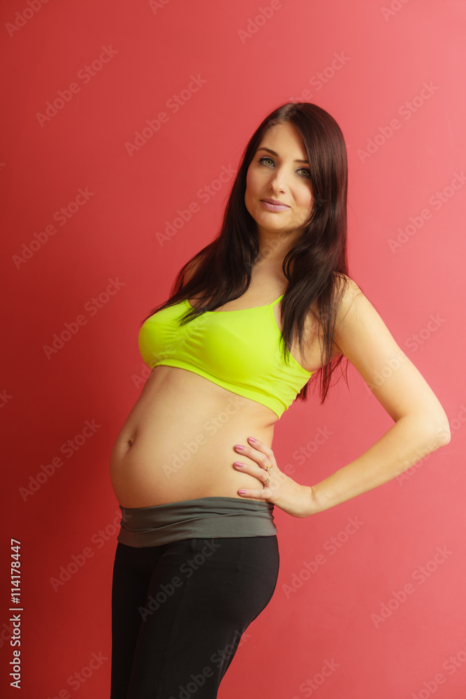 Long hair fit pregnant woman on red Long hair fit pregnant woman on red