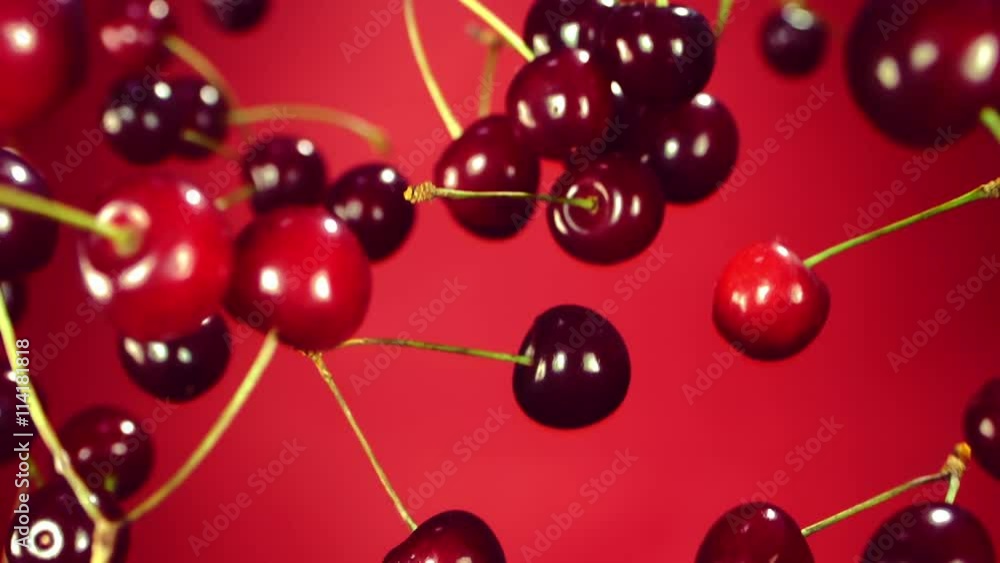 Cherry flies through the air and rotates a red background, slow motion Cherry flies through the air and rotates a red background, slow motion