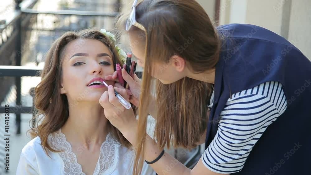 Make up artist paints lips for bride Make up artist paints lips for bride