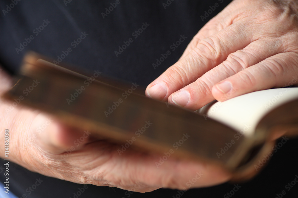 Closeup of an older man reading a vintage book