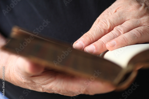 Closeup of an older man reading a vintage book