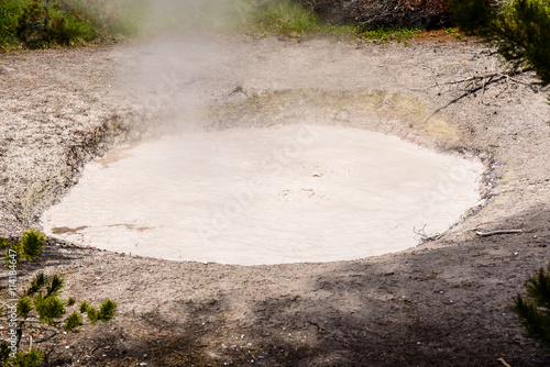 Steaming aqua hot spring, Yellowstone. / Clear, aqua hot spring with deep central hole, steam and limy shoreline,  West Thumb area of Yellowstone National Park.