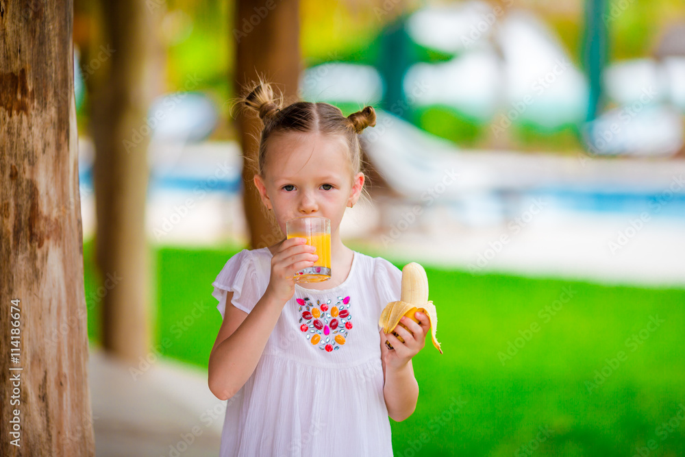 Adorable little girl having breakfast at outdoor cafe Adorable little girl having breakfast at outdoor cafe
