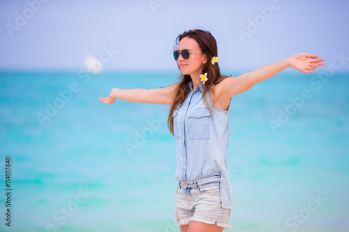 Beautiful girl during tropical beach vacation. Enjoy suumer vacation alone on the beach at Africa with frangipani flowers in her hair