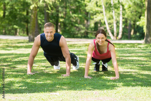 Couple Doing Push-ups In Park
