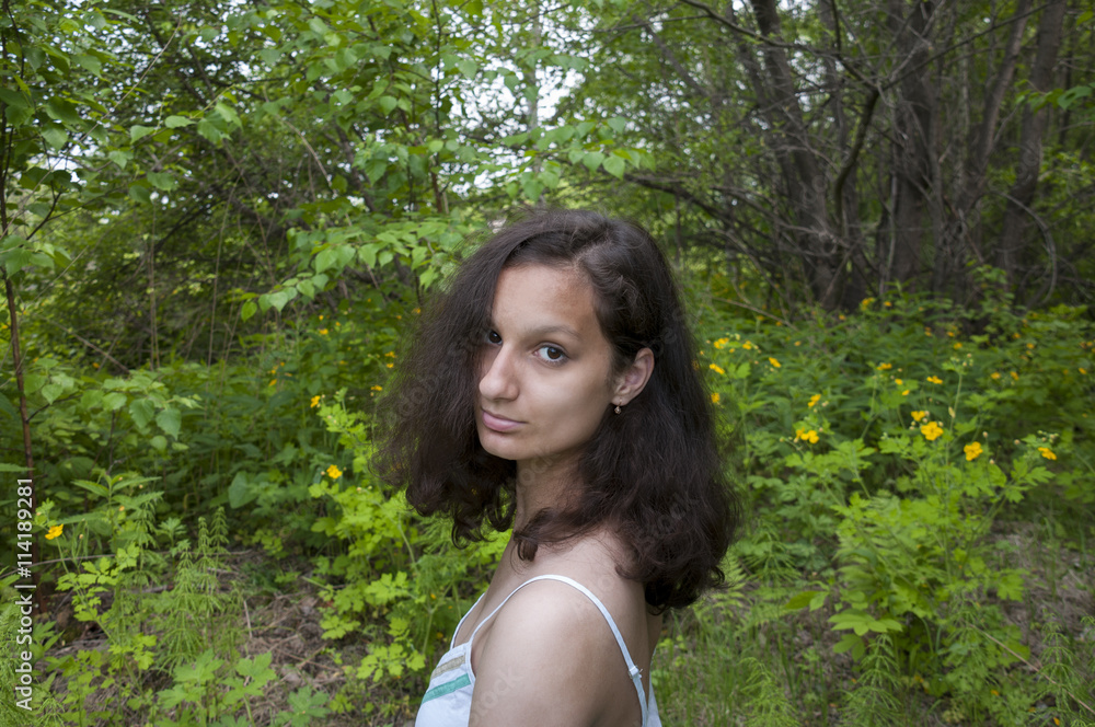 Portrait curly girl in the of forest flowers background Portrait curly girl in the of forest flowers background