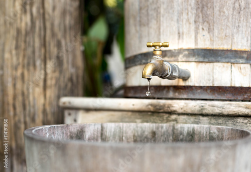 Concept saving water wooden water  tank with golden tap and in s photo