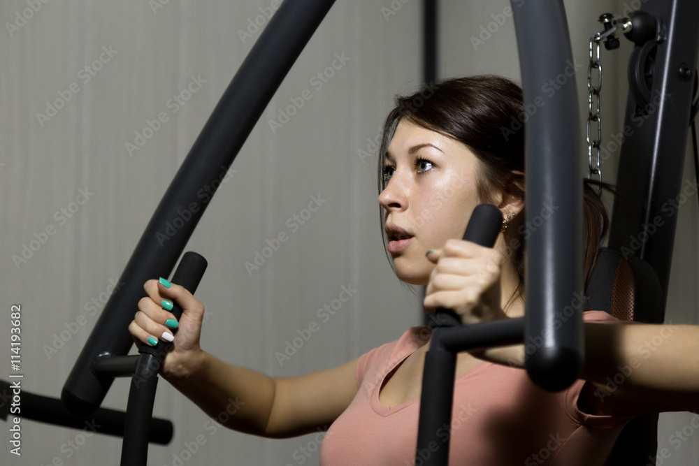 young woman is engaged in sports and gymnastics in the gym