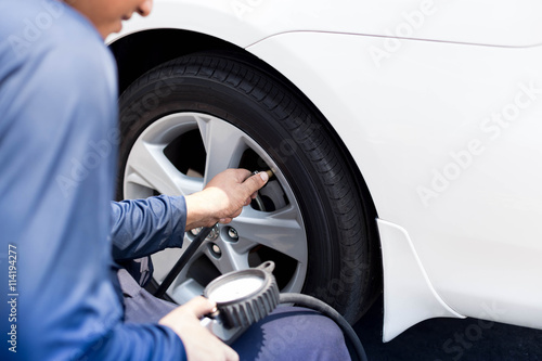 Man checking tire air pressure © bignai
