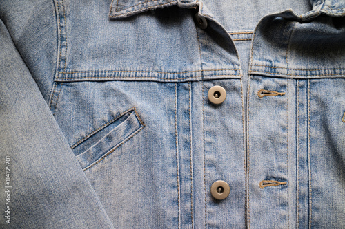 Close up aged denim texture. Old blue jeans jacket with stiched