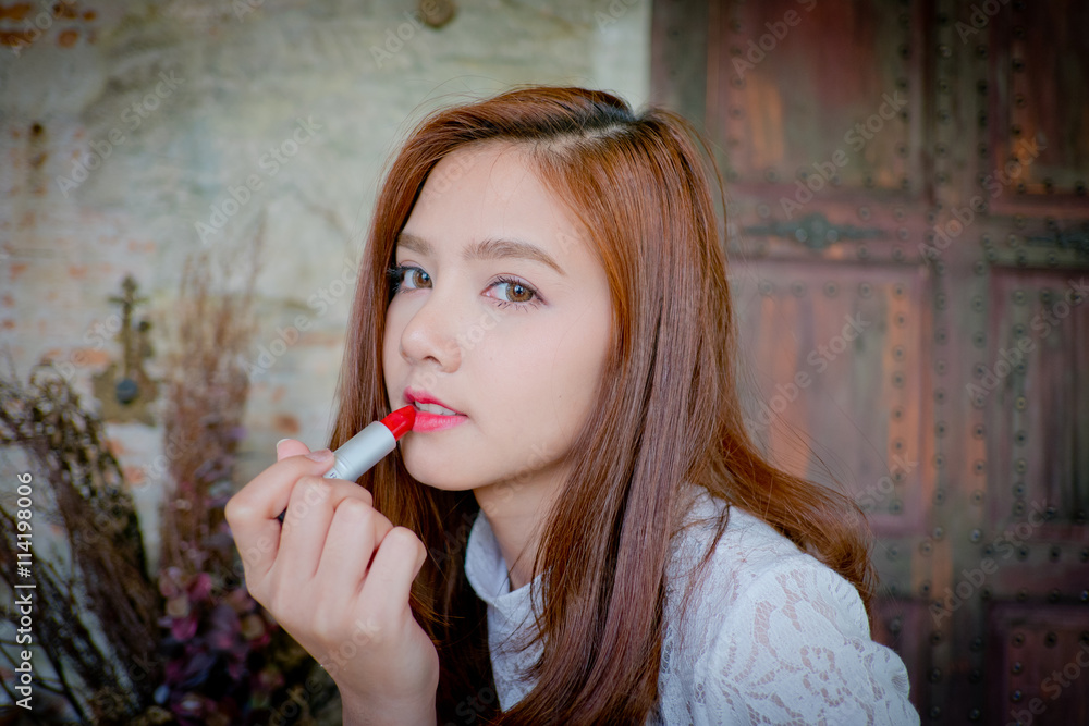 The little girl was lip -stick and makeup .