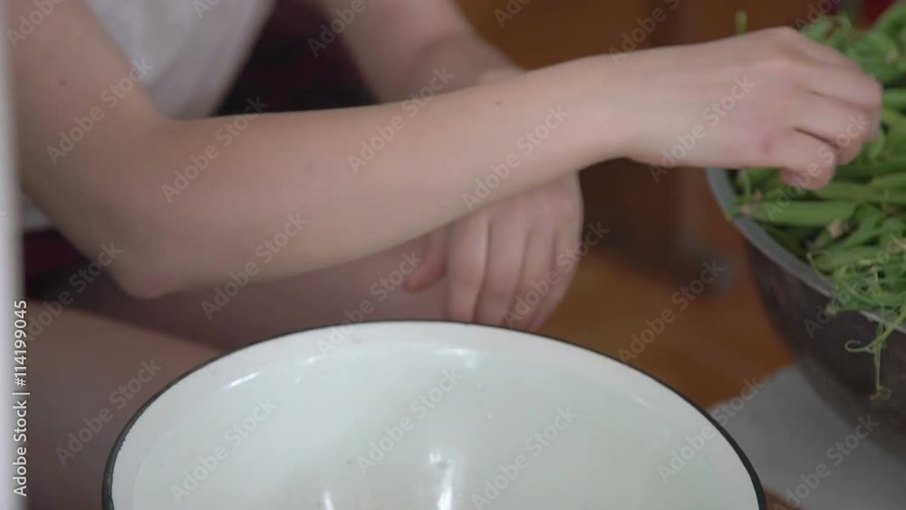 Young girl's hands shelling green peas in the village Young girl's hands shelling green peas in the village