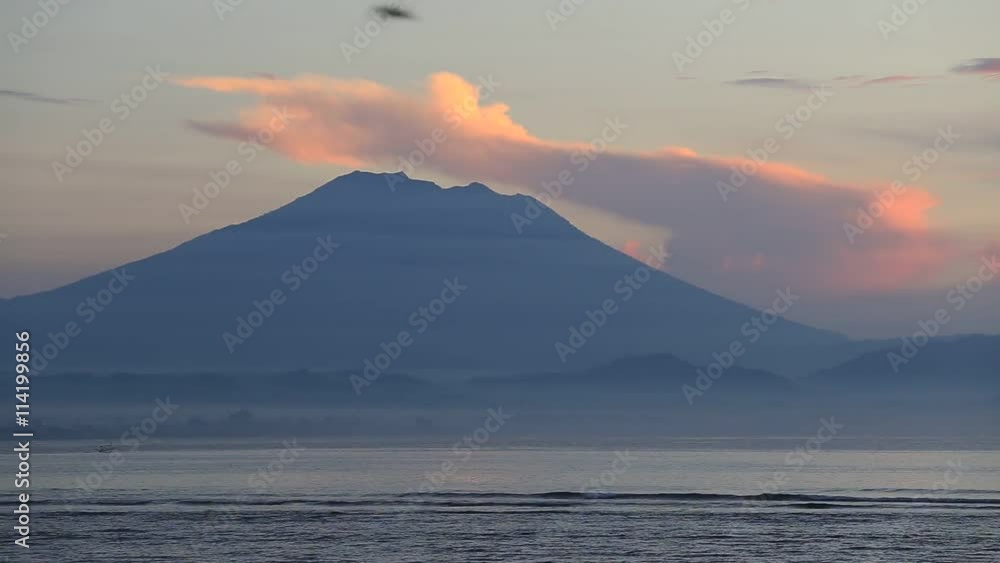 Sea water wave with views of the volcano during the dawn. Sanur, island Bali, Indonesia Sea water wave with views of the volcano during the dawn. Sanur, island Bali, Indonesia