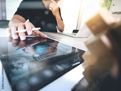 Fotografie creative hand working digital tablet and wood puzzle with laptop