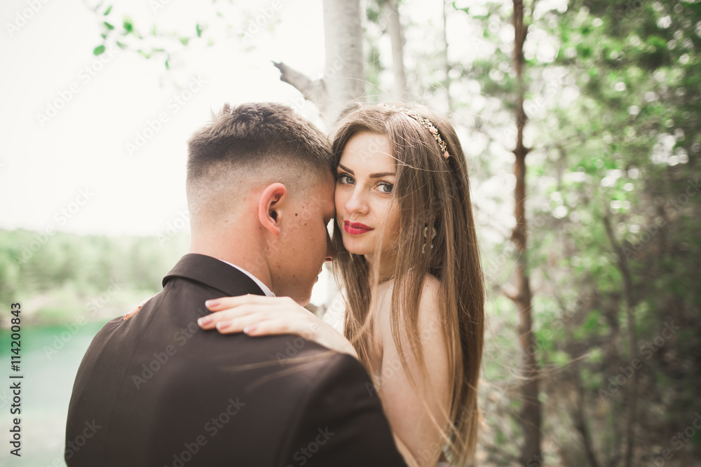 Fototapeta premium Kissing wedding couple in spring nature close-up portrait