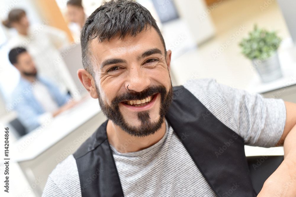 Cheerful trendy bearded guy in office Cheerful trendy bearded guy in office