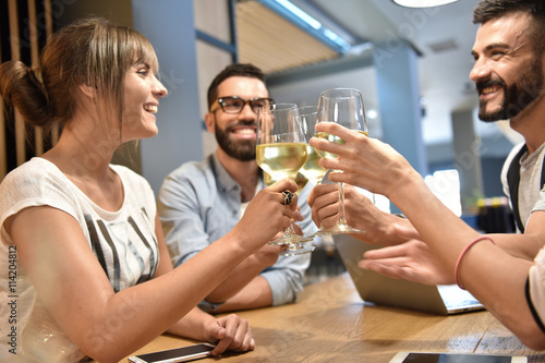 Group of young people cheering with wine glasses