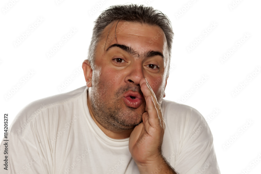 funny fat man whispers with his hand next to his mouth funny fat man whispers with his hand next to his mouth