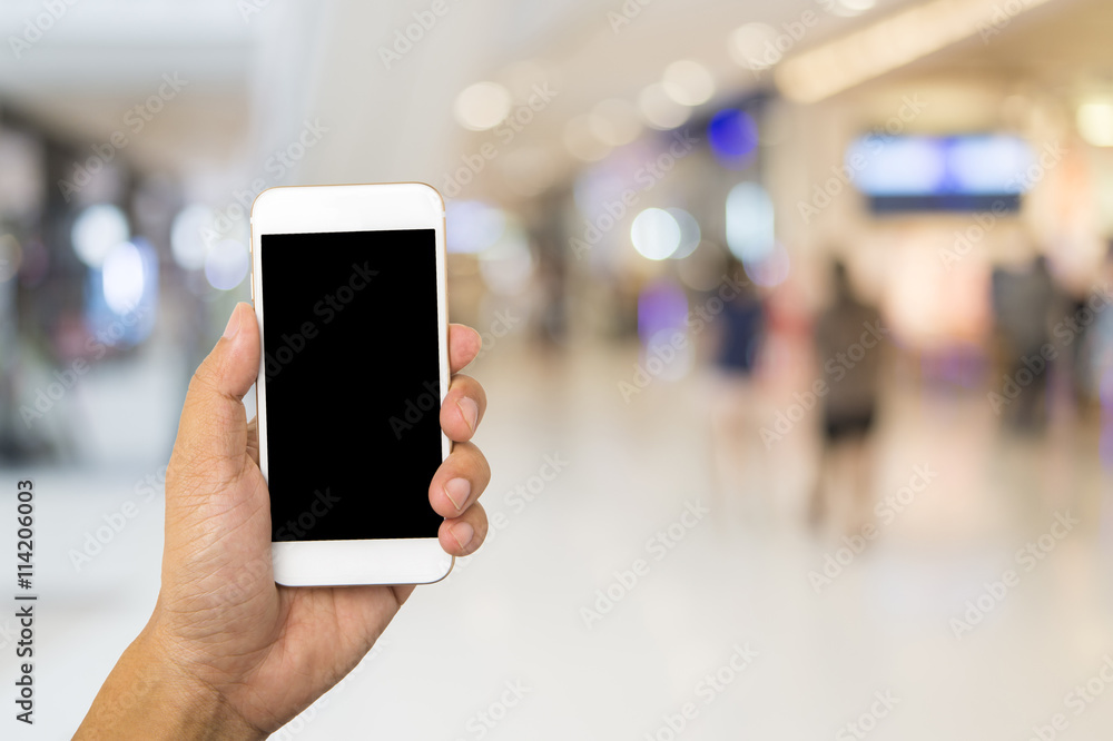 Hand use smartphone on blur shopping mall background
