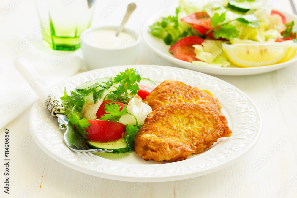 Pork chop in batter with vegetable salad. Pork chop in batter with vegetable salad.