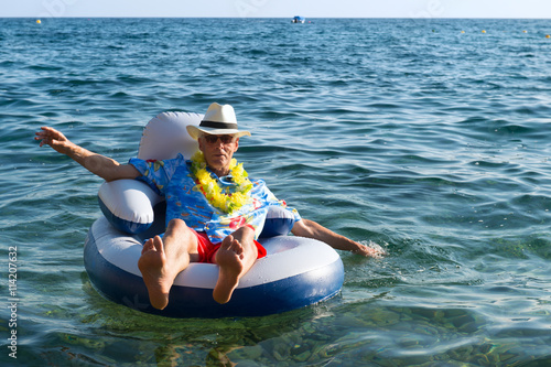 Senior man floating in sea photo