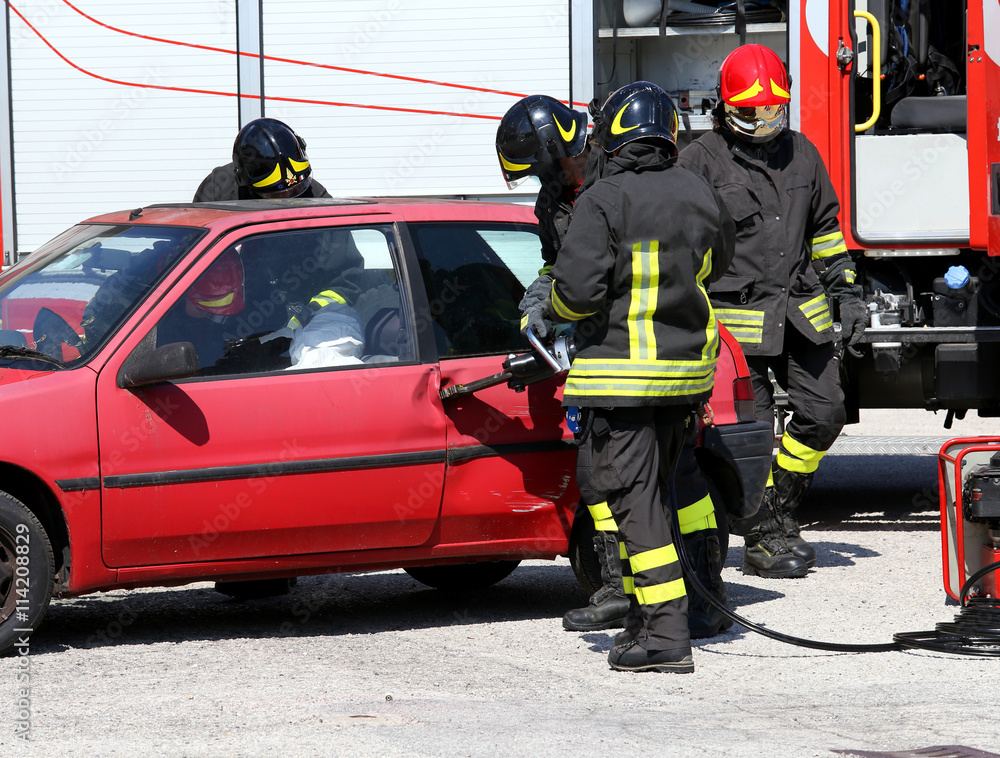 Firefighter opens car door with pneumatic shears after the traff