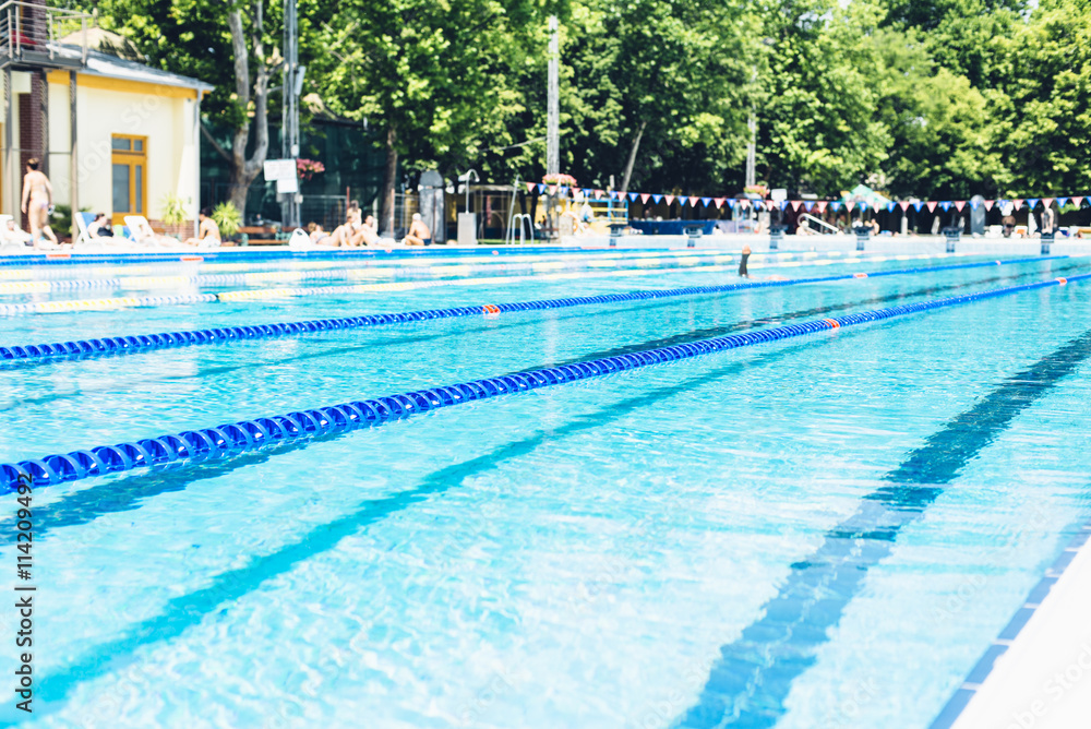 Swimming lanes with clear blue water in public swimming pool in summer 