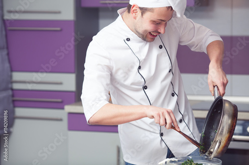 Photography Vegetarian food concept. Smiling chef in white uniform cooking